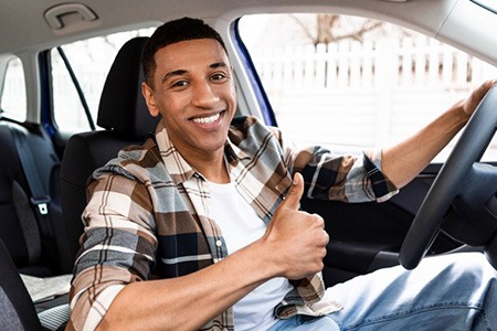 Man in car gives thumbs-up